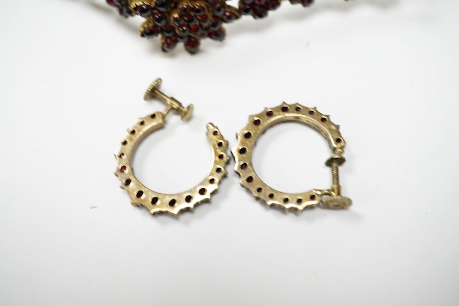 Three items of gilt white metal and garnet paste cluster set jewellery, comprising a bracelet, bangle and pair of Czechoslovakian earrings. Condition - fair